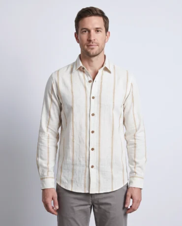 Wheat Loom khadi striped shirt worn untucked, front view showing the widely spaced gold lines, point collar and coconut-shell buttons